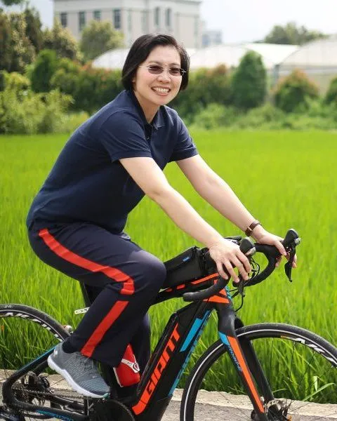 徐欣瑩在稻田邊騎腳踏車