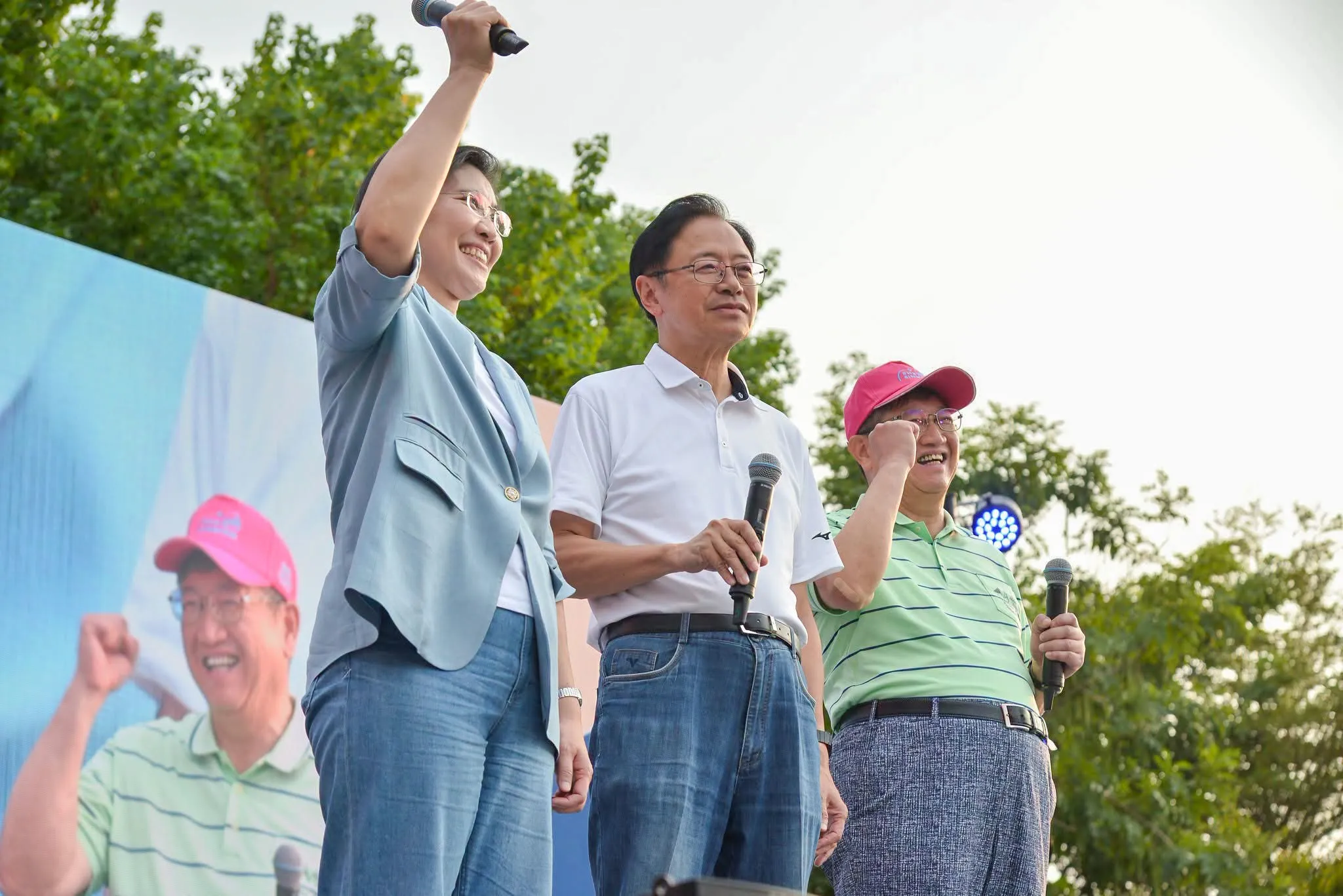 草地音樂會台上,楊文科縣長、張善政市長和徐欣瑩一起舉手